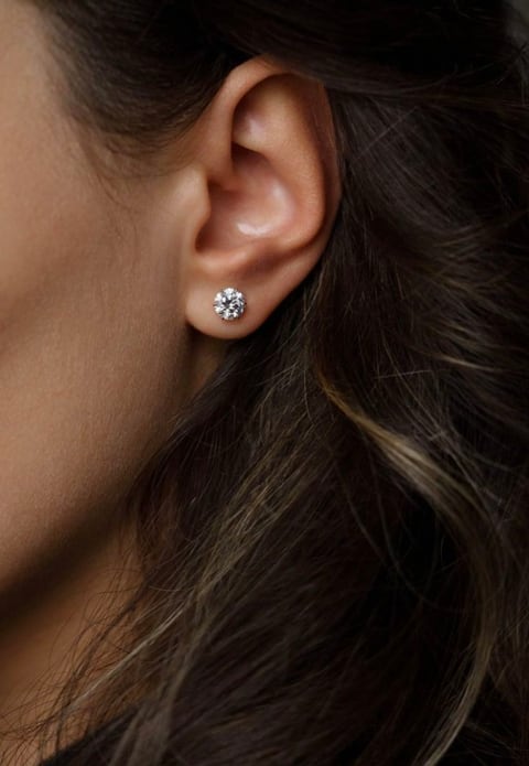 Woman wearing a single diamond stud earring