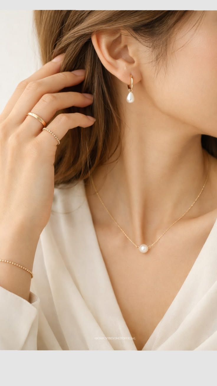 Gold hoop pearl-drop earring, pearl pendant, stacked gold rings and beaded bracelet