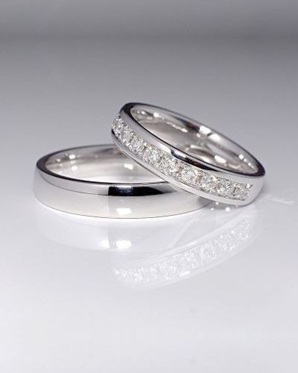 Pair of white gold wedding bands, one set with channel diamonds