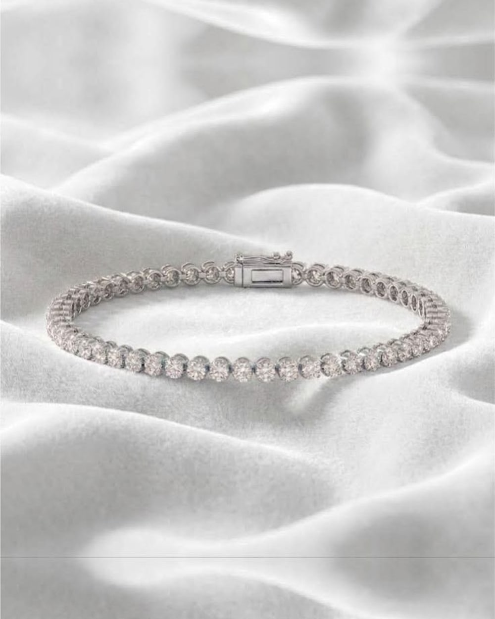 White gold round diamond tennis bracelet on soft white velvet